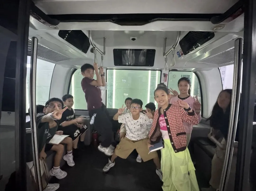 Children pose inside the cabin of a driverless shuttle bus