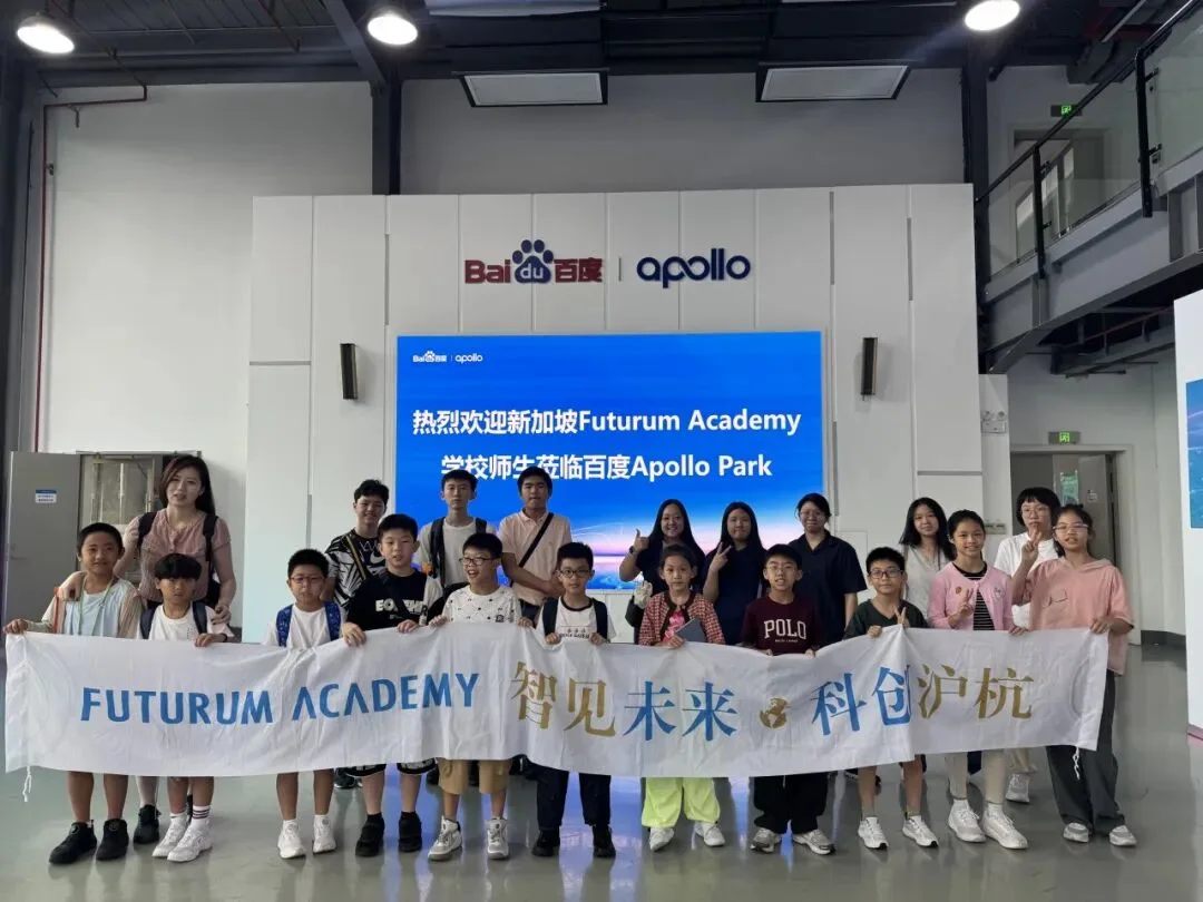 The group holds a Futurum Academy banner at Baidu Apollo Park under a welcome screen