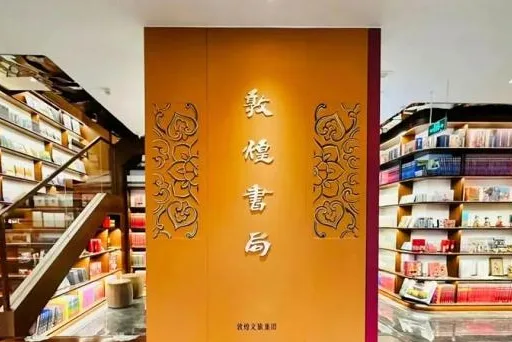 Bookshop interior with a tall carved amber panel between book-filled shelves and a staircase