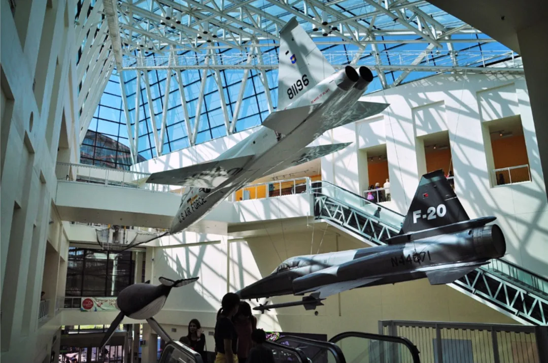 Aircraft hung in a glass-roofed museum atrium, including a US Air Force jet and an F-20.
