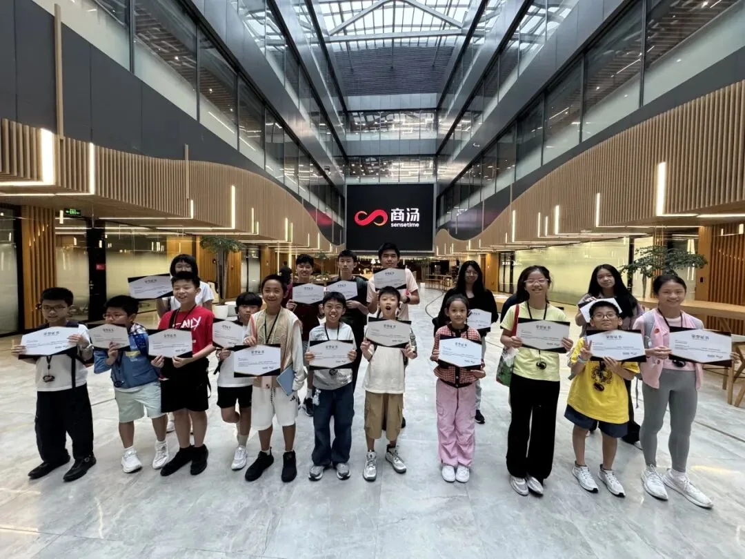 The group holds certificates in SenseTime's atrium beneath the company logo wall