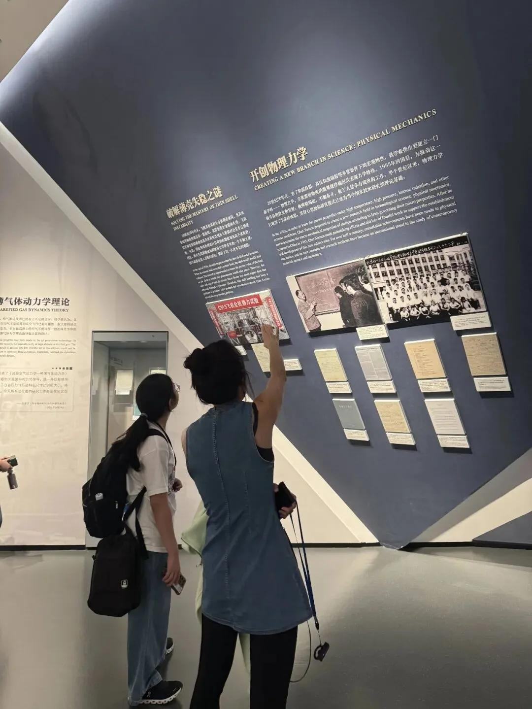 Visitors study a museum panel titled Created a New Branch in Science: Physical Mechanics
