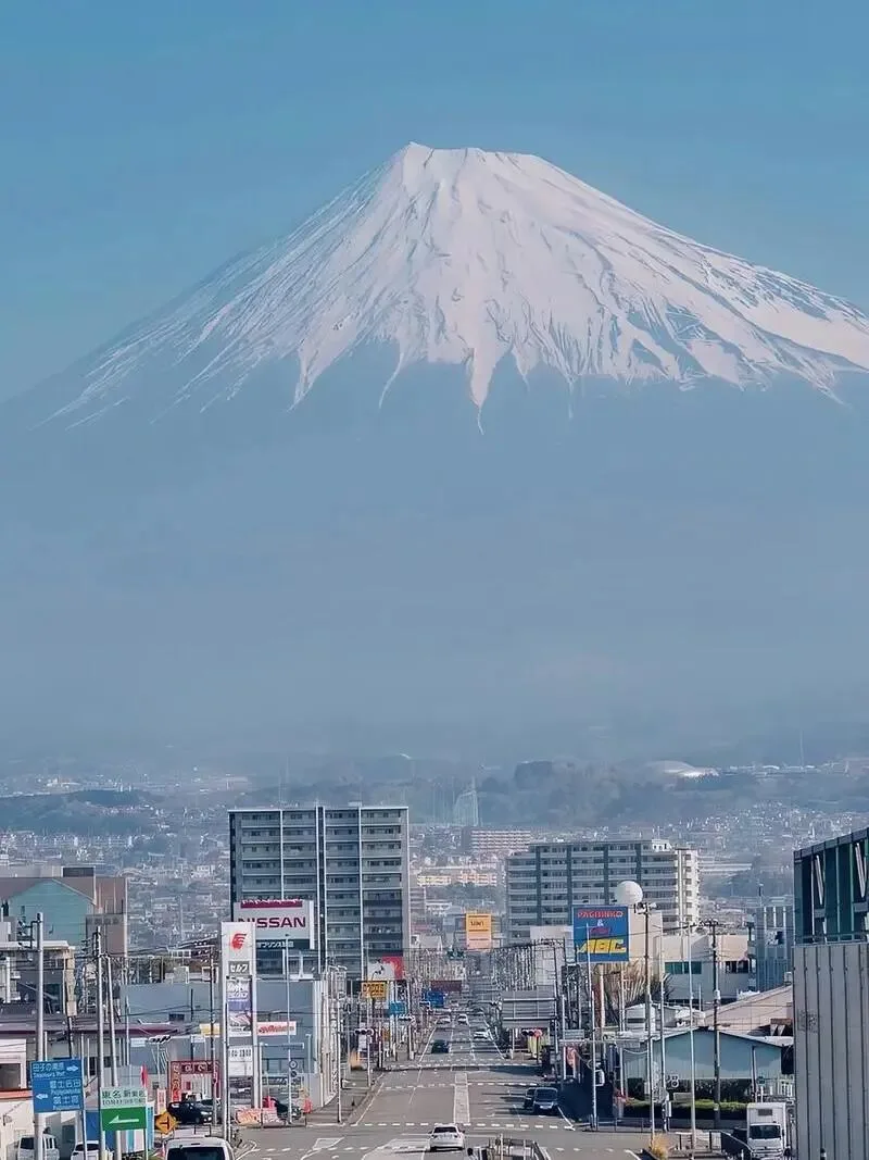 Snow-capped Mount Fuji rising above a Japanese town and its main street